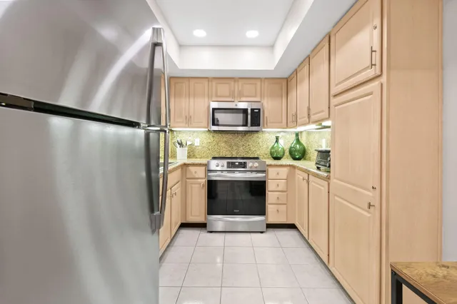 a kitchen with stainless steel appliances a refrigerator and a stove top oven