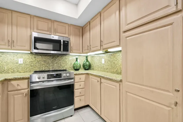 a kitchen with granite countertop white cabinets and stainless steel appliances