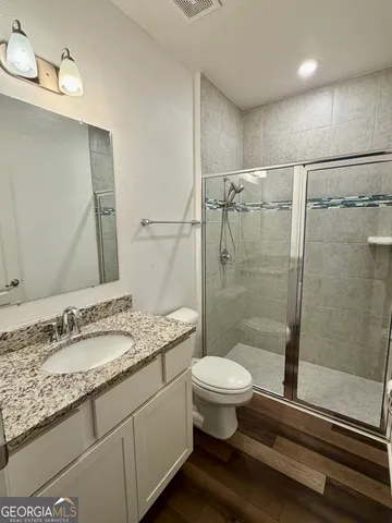 a bathroom with a granite countertop sink and a large mirror