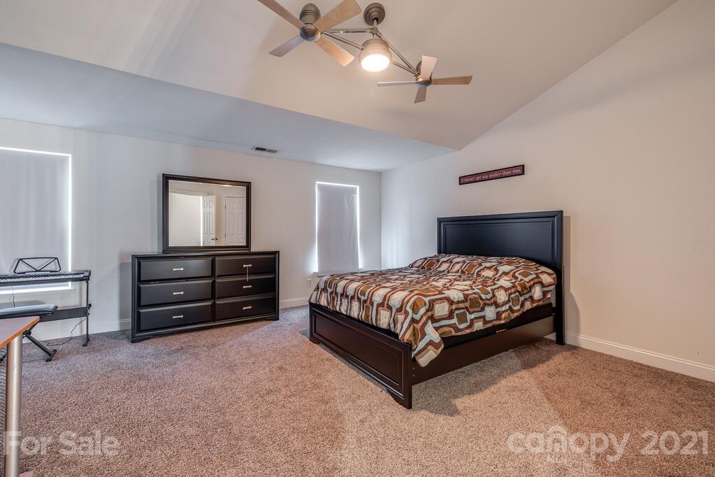 415 Fischer Road Fort Mill, SC 29715 - Photo 41 of 48 a bedroom with a bed and a chandelier