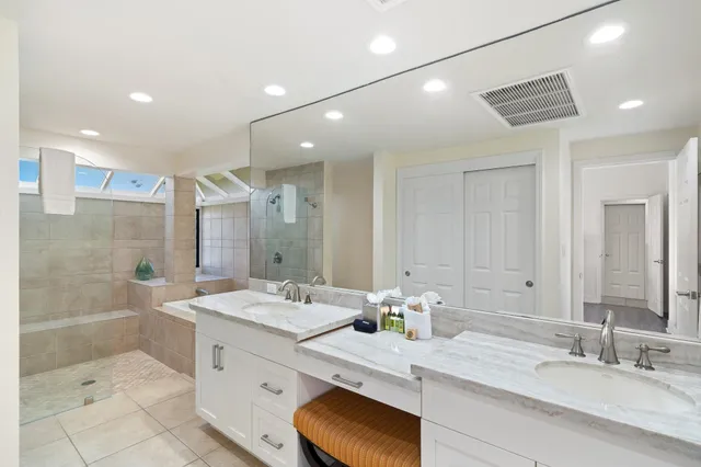 a bathroom with a granite countertop sink mirror and shower