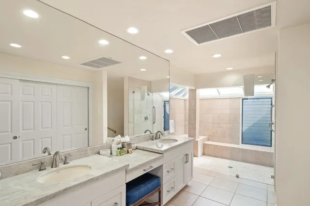 a bathroom with a granite countertop sink mirror and a shower