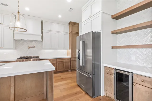 a kitchen with stainless steel appliances a refrigerator sink and stove