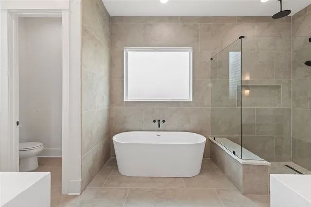 a white bath tub sitting next to a white toilet