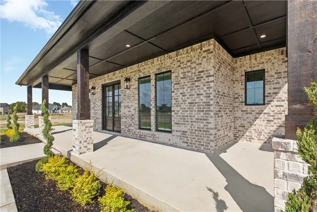 a view of a patio with a table and chairs under an umbrella with a fireplace