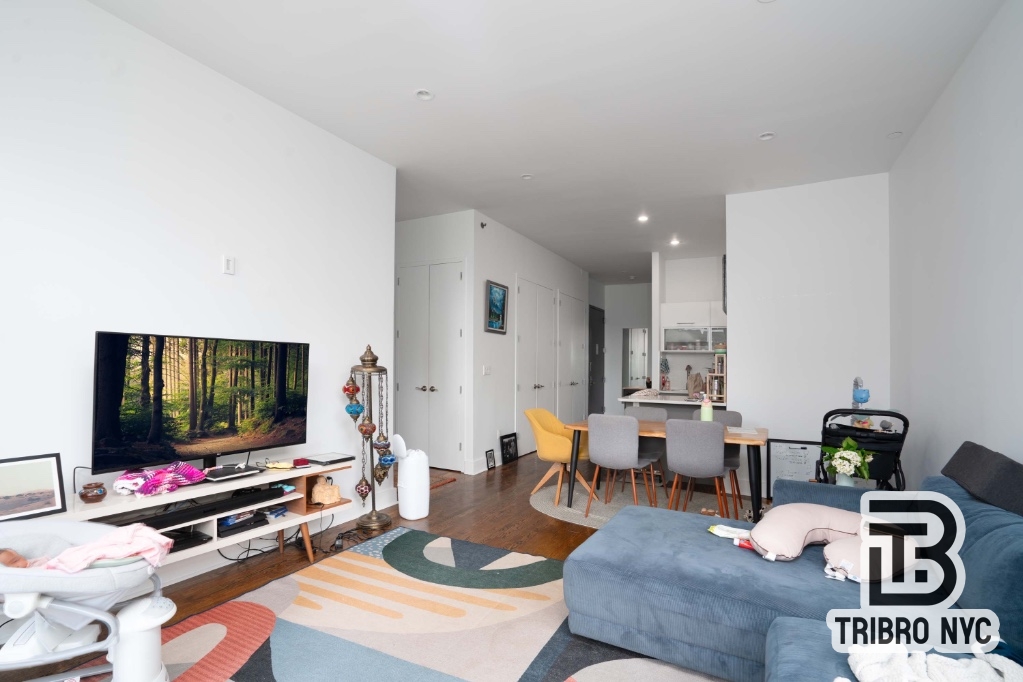 230 East 124th Street, Unit 4B Manhattan, NY 10035 - Photo 3 of 8 a living room with furniture and a flat screen tv