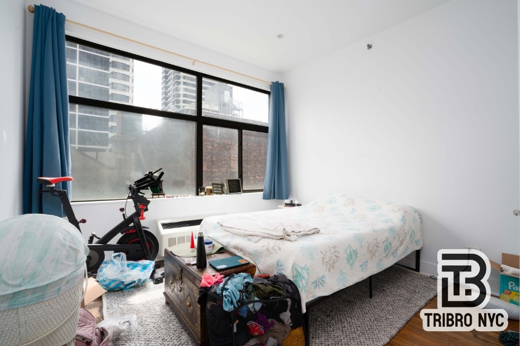 230 East 124th Street, Unit 4B Manhattan, NY 10035 - Photo 5 of 8 a bed room with a bed and a window