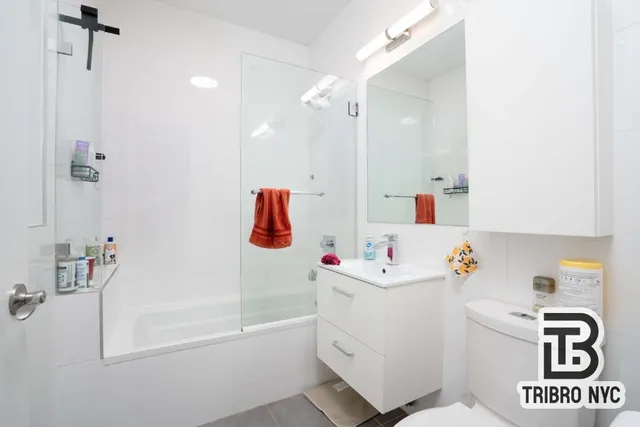 a bathroom with a sink mirror toilet and bath tub
