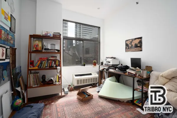 a living room with furniture gym equipment and a window