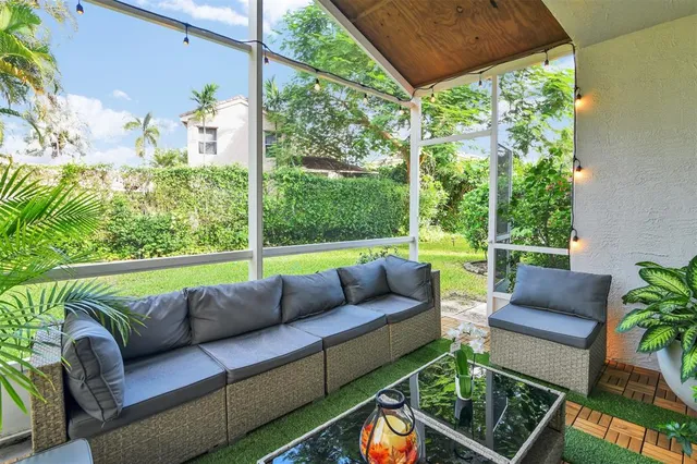 an outdoor living room with patio a couch and a garden