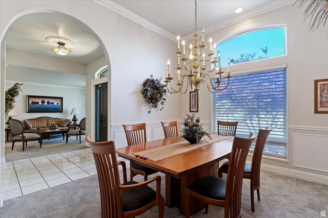 1924 North 2000th Street East Layton, UT 84040 - Photo 9 of 41 Dining space featuring light carpet, arched walkways, ornamental molding, a chandelier, and a decorative wall