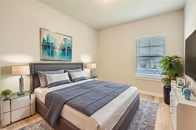 a bedroom with bed and night stand