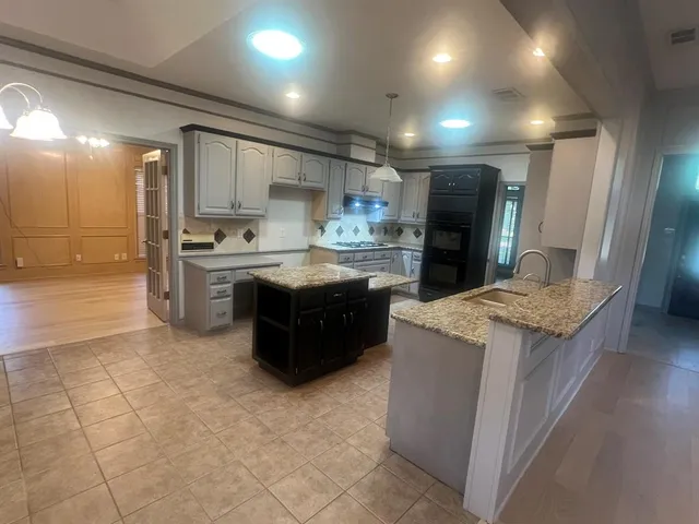 a kitchen with stainless steel appliances granite countertop a stove a sink a refrigerator and a oven