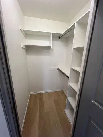 a view of walk in closet with empty racks