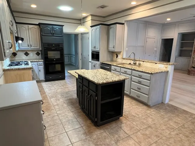 a kitchen with stainless steel appliances granite countertop a stove oven and a refrigerator