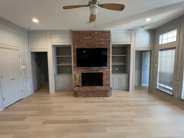 a view of an empty room with a fireplace and a window