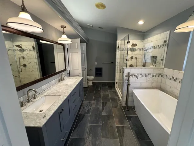 a bathroom with a tub sink and mirror