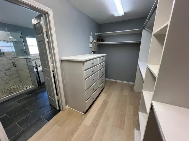 a view of walk in closet with empty racks