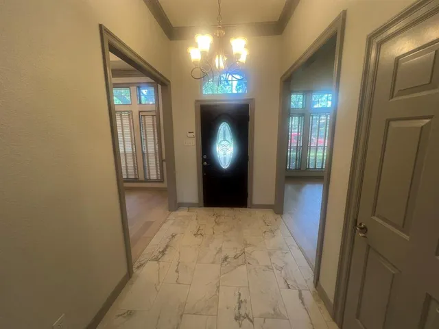 a view of a hallway with wooden floor and a mirror