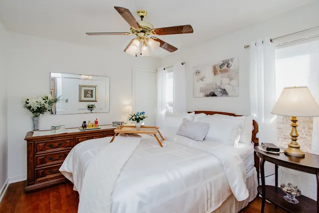 a bedroom with a bed and a lamp on dresser