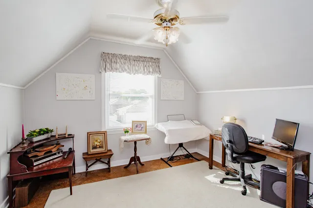 a view of a workspace with furniture and a window