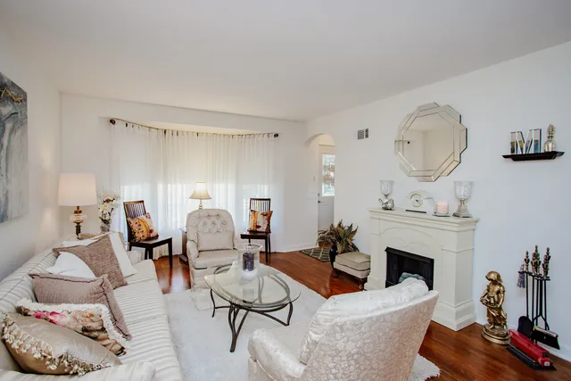 a living room with furniture a fireplace and a potted plant