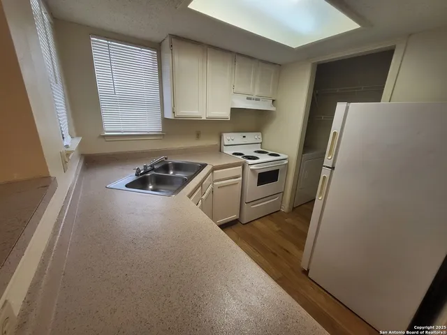 a kitchen with a stove a refrigerator and a sink