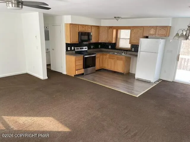 a view of kitchen with stainless steel appliances kitchen island a stove and a refrigerator