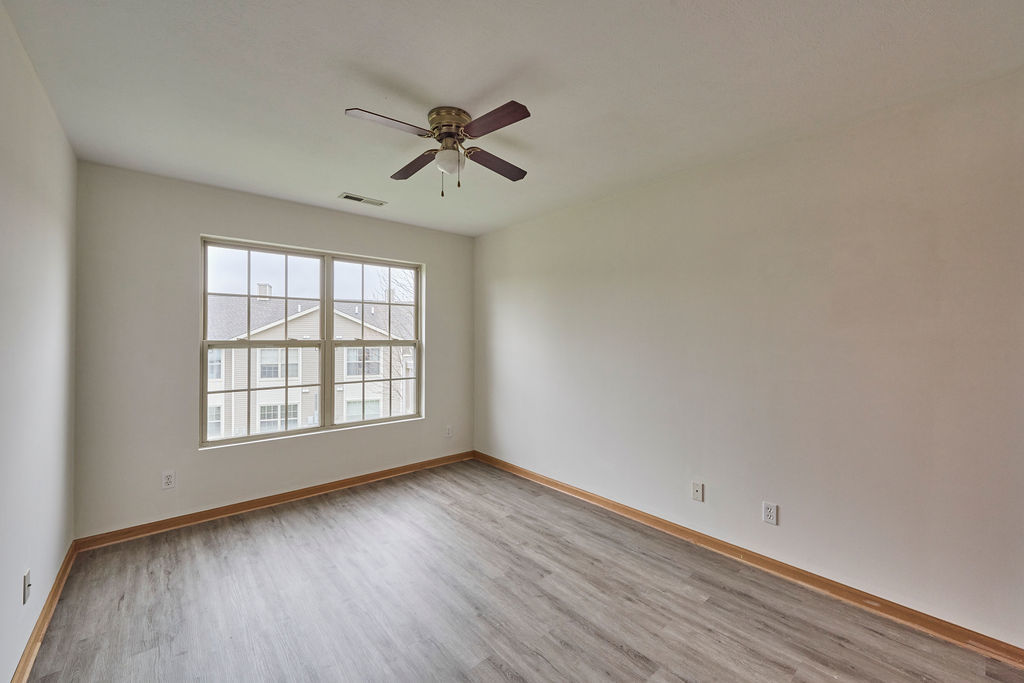 962 Arvle Circle, Unit 962 Sycamore, IL 60178 - Photo 18 of 18 a view of an empty room with wooden floor and a window