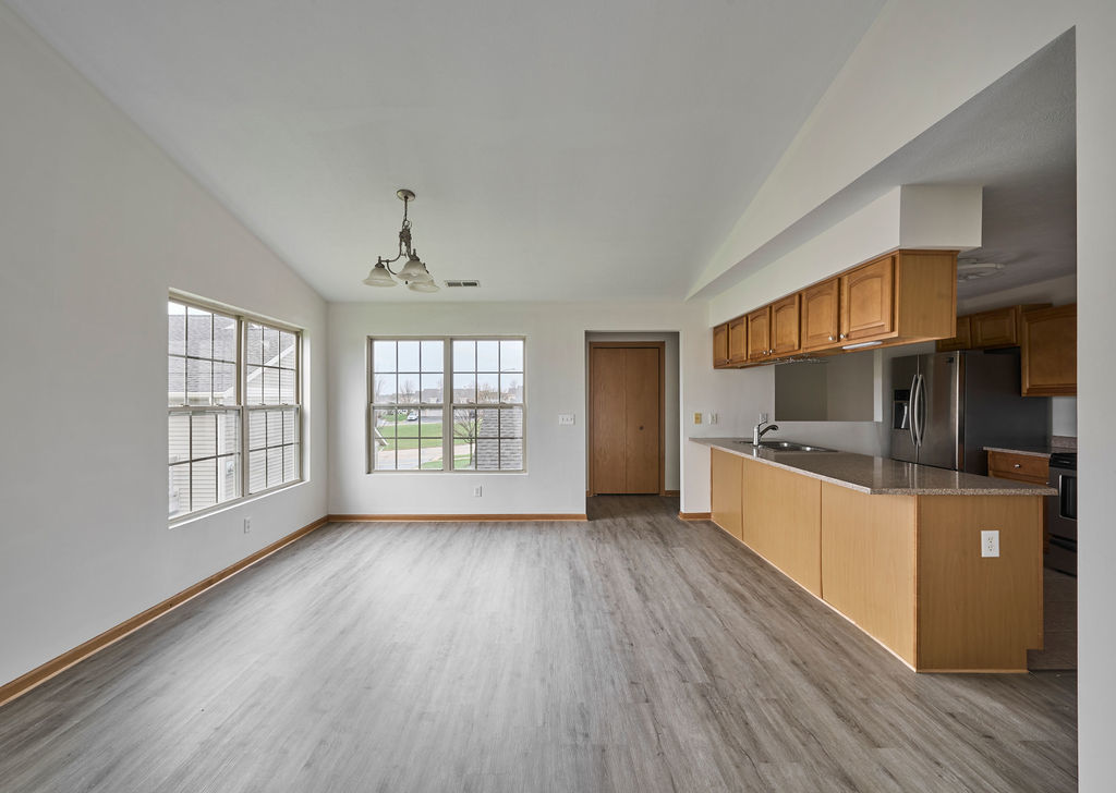 962 Arvle Circle, Unit 962 Sycamore, IL 60178 - Photo 3 of 18 a large living room with stainless steel appliances wooden floors and white walls