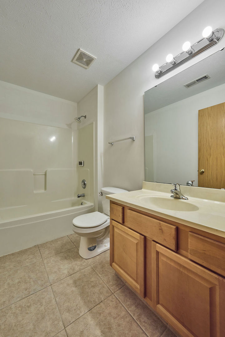 962 Arvle Circle, Unit 962 Sycamore, IL 60178 - Photo 6 of 18 a bathroom with a toilet a sink a mirror a bathtub and vanity