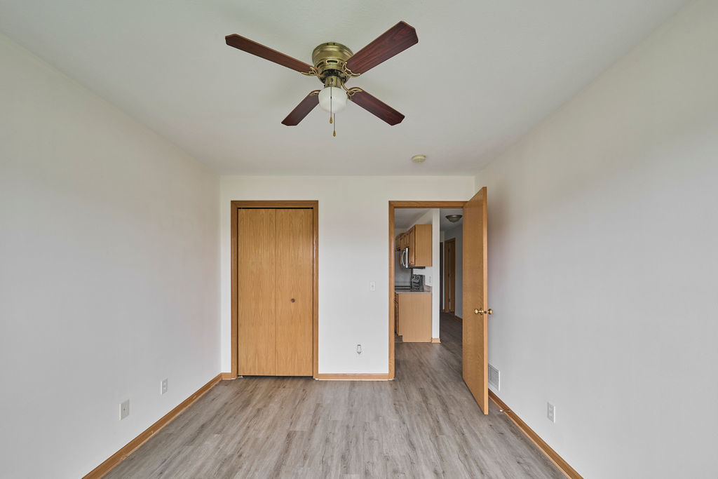 962 Arvle Circle, Unit 962 Sycamore, IL 60178 - Photo 8 of 18 an empty room to hallway with wooden floor wooden door and a ceiling fan