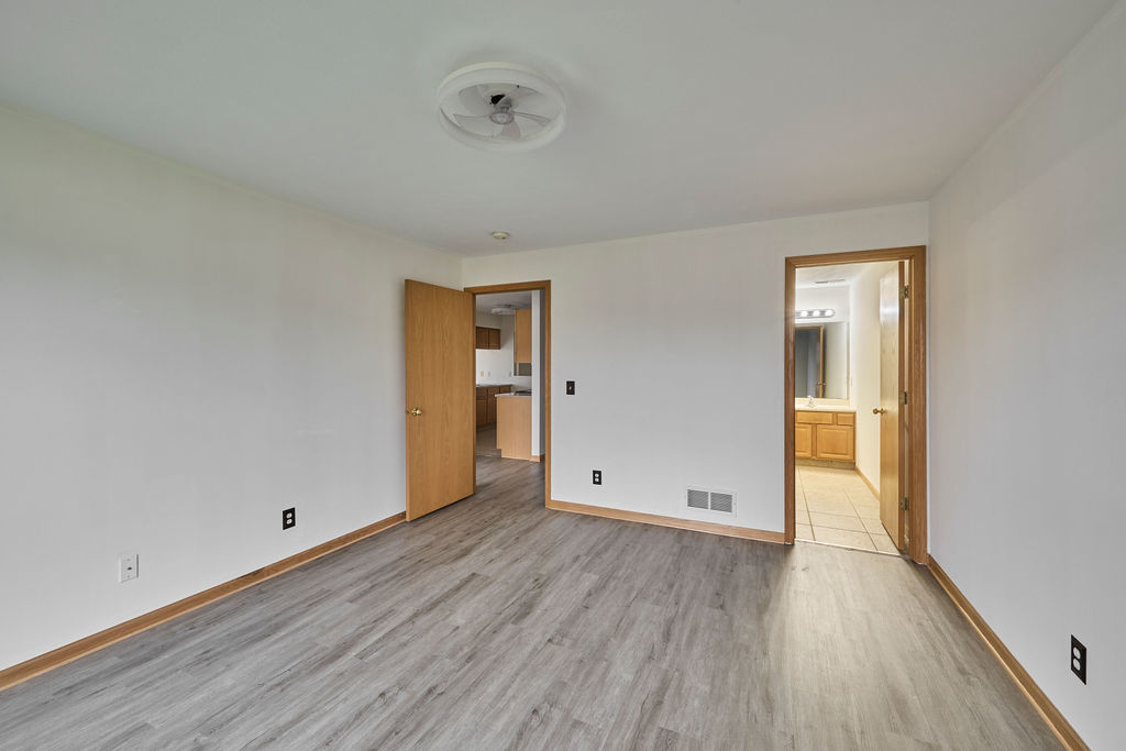 962 Arvle Circle, Unit 962 Sycamore, IL 60178 - Photo 10 of 18 a view of an empty room with wooden floor and a window