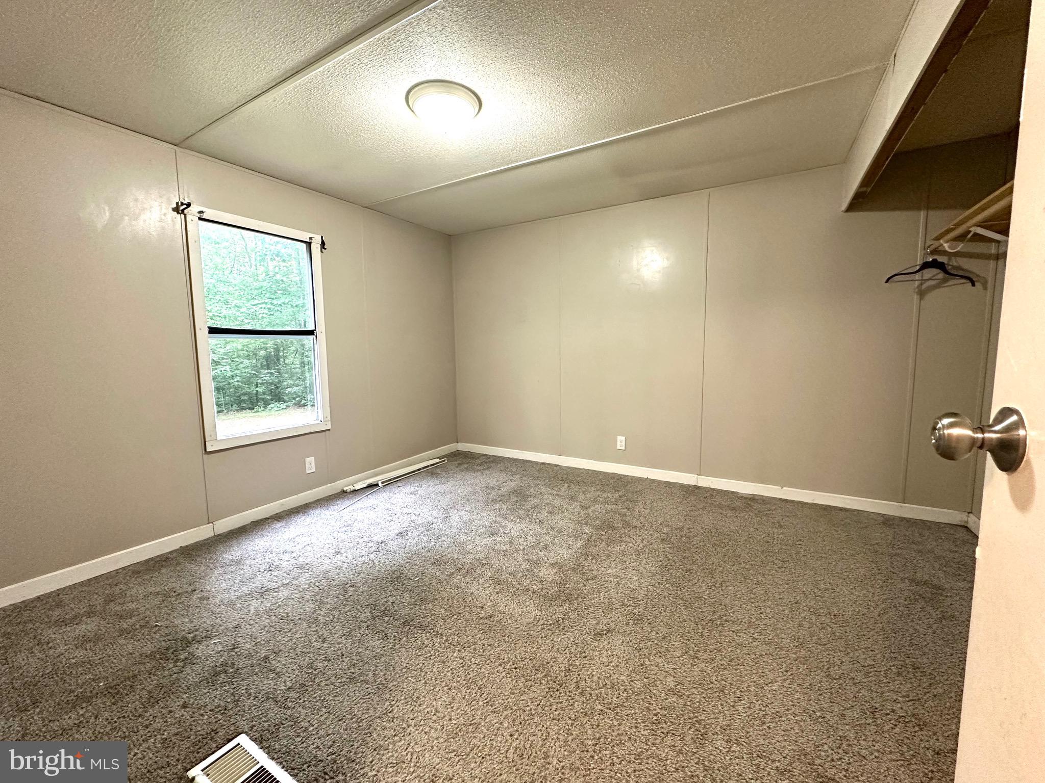 606 Dogwood Acres Road Bumpass, VA 23024 - Photo 12 of 20 an empty room with a empty space and windows