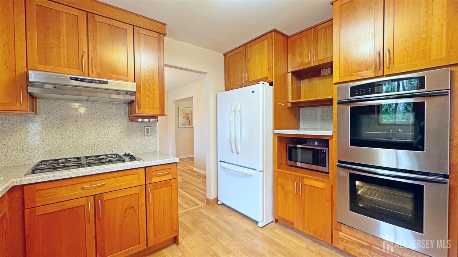 26 Lucille Court Edison, NJ 08820 - Photo 6 of 22 a kitchen with stainless steel appliances granite countertop a refrigerator a stove and a microwave