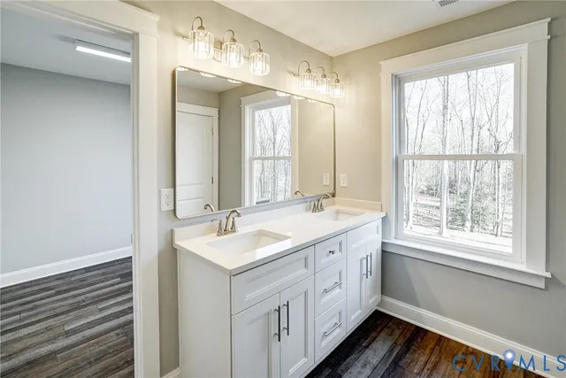 a bathroom with a double vanity sink and mirror with window