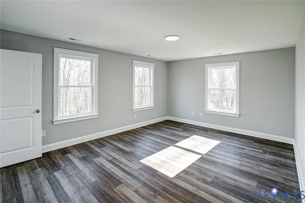 a view of wooden floor in an empty room with a window