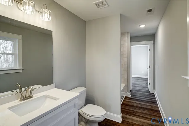 a bathroom with a sink a toilet a shower and a window