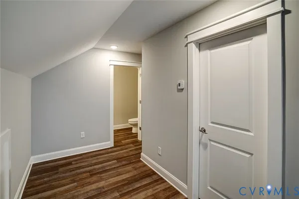 a view of a hallway with wooden floor and closet
