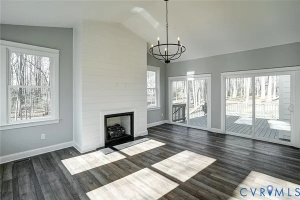 a view of a livingroom with furniture window wooden floor and a fireplace