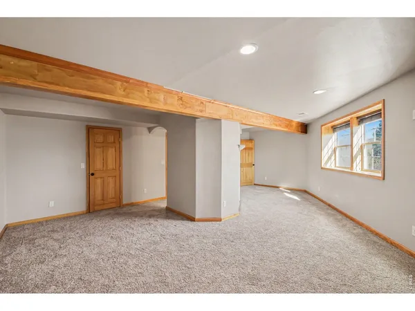 a view of an empty room with fireplace and a window