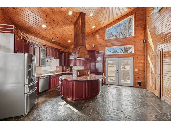 a kitchen view with stainless steel appliances wooden floor and dining table