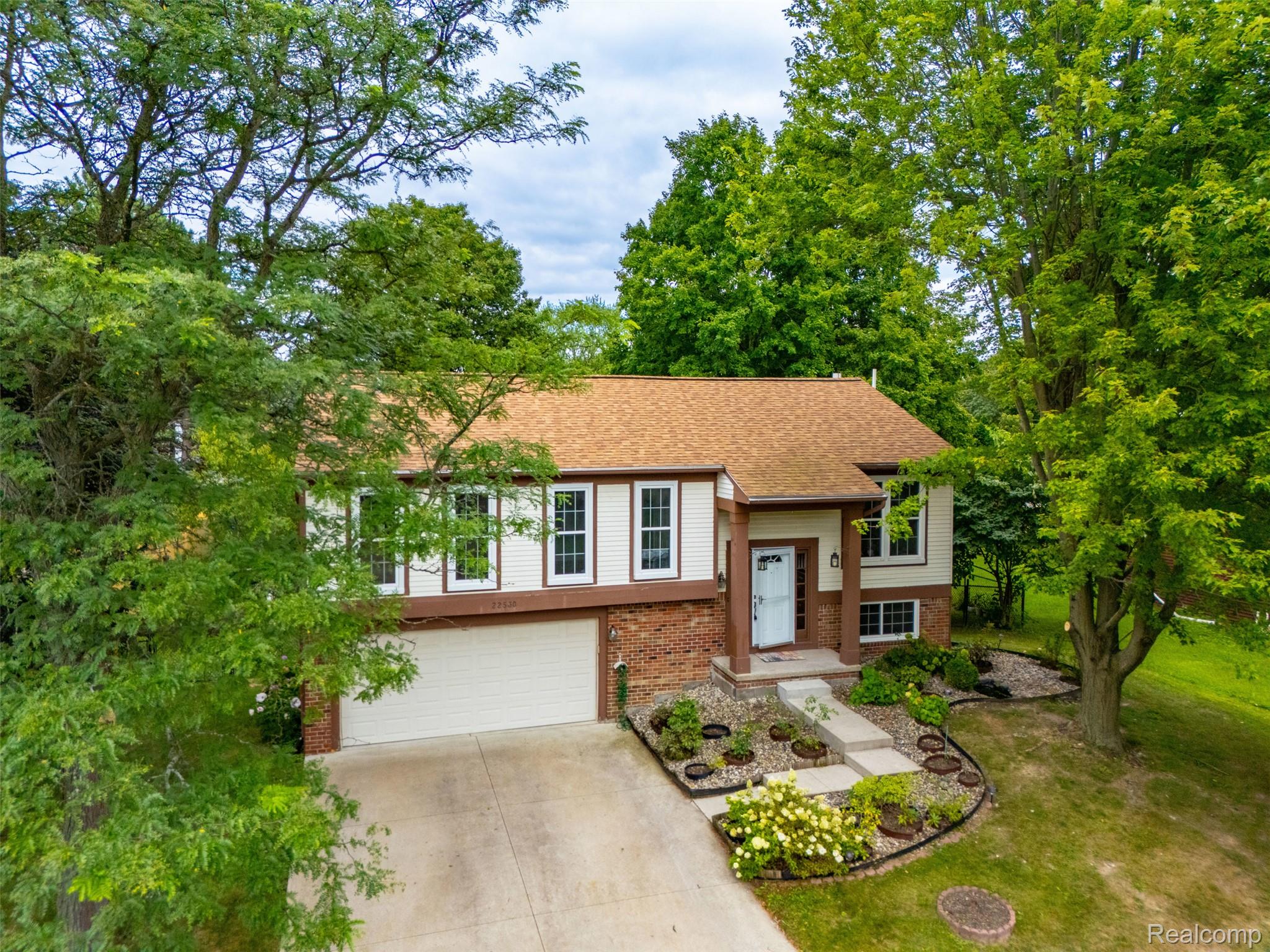 22530 Sheridan Road Novi, MI 48375 - Photo 34 of 50 Bi-level home with brick siding, concrete driveway, a garage, and roof with shingles