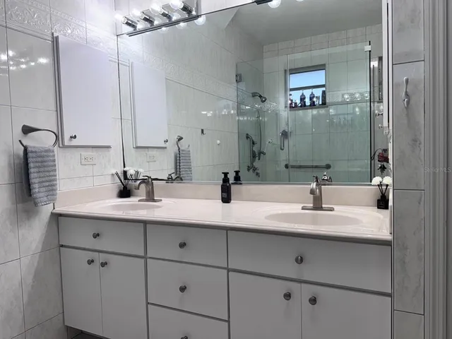 a bathroom with double sink and a mirror