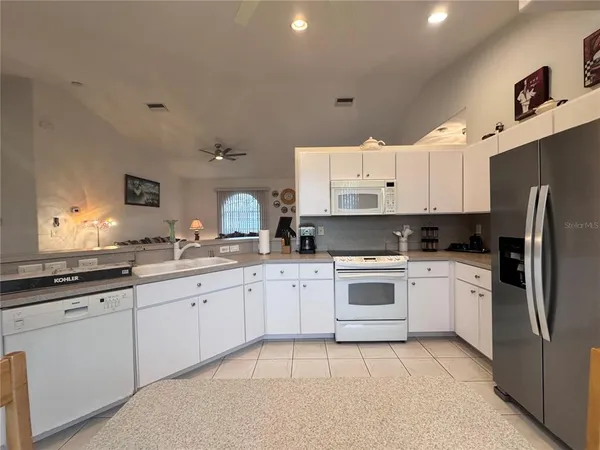 a large kitchen with stainless steel appliances granite countertop a stove a sink dishwasher and a refrigerator