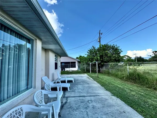 a view of a chairs and table in backyard of a house