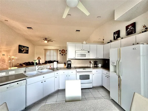 a kitchen with white cabinets and white appliances