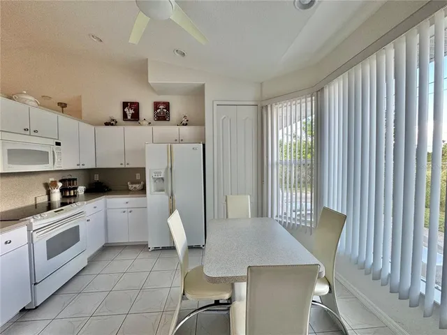 a kitchen with a white cabinets and chairs