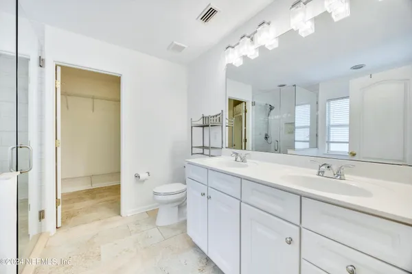 a bathroom with a double vanity sink mirror and toilet