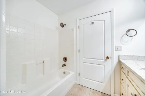 a bathroom with a granite countertop sink a mirror a shower and a bathtub